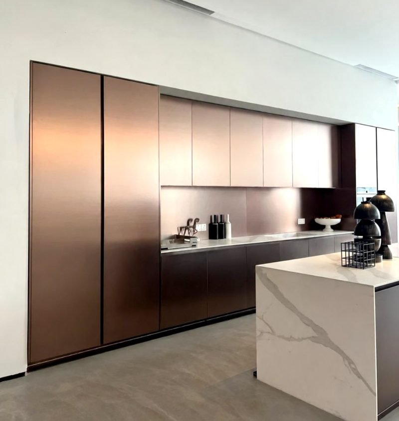 Kitchen with bronze-finish metal cupboard fronts and a marble island